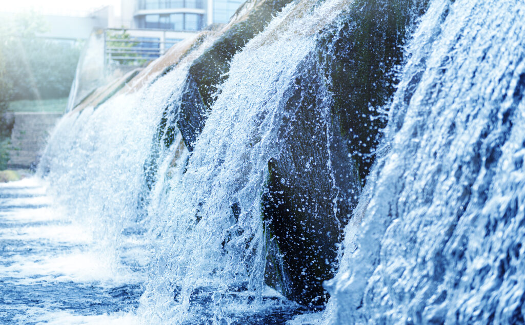 Waste water treatment plant. Modern urban wastewater treatment plant. Cold transparent water of decorative artificial waterfall.